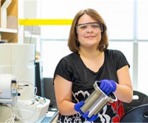 WPI professor Marion Emmert holds the drive unit of an all-electric vehicle in her lab at Gateway Park.