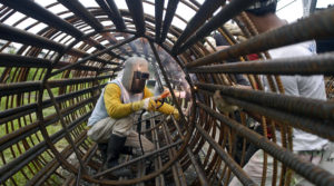Man working inside a large reinforced steel tube
